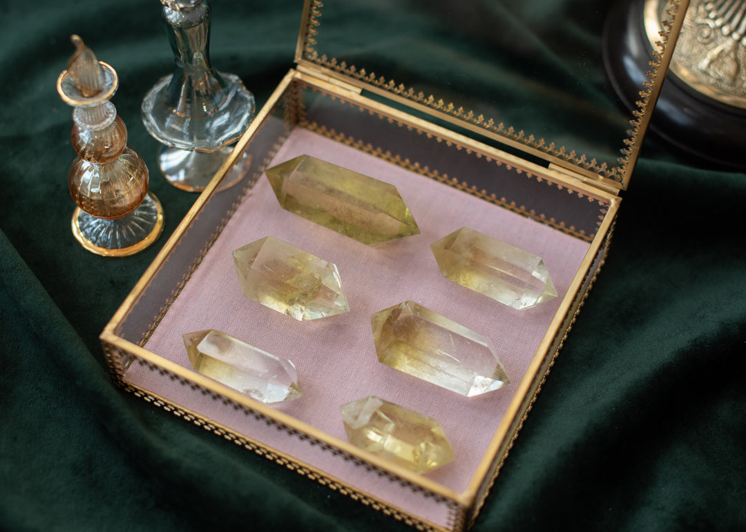 •Citrin Kristallspitze
•Citrin Doppelender
•Citrin für Fülle
• Gelber Heilstein
• Manifestationskristall
• Natürlicher Citrin
• Heilender Citrinstab
• Füllestein
•Chakra-Balance-Kristall
Sechs funkelnde Citrin Doppelender in einer edlen, goldgerahmten Glasbox auf rosa Samtkissen, umgeben von magischen Glasflakons, auf grünem Samtuntergrund – natürliche Kristallenergie für Manifestation, Klarheit und Lebensfreude.